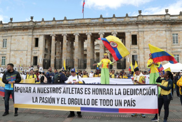 Personas sostienen una pancarta durante una protesta convocada por el Comité Olímpico Colombiano este lunes, en la Plaza de Bolívar en Bogotá (Colombia). 