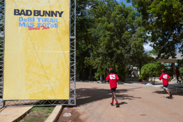  Personas pasan frente a una valla publicitaria previo al concierto del cantante puertorriqueño Bad Bunny, este jueves, en Santo Domingo (República Dominicana).