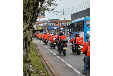 Domiciliarios de Rappi protestaron encadenados simbólicamente a sus maletas en la avenida Santander y el Centro de Manizales. Rechazan tarifas bajas y exigen diálogo con la empresa.