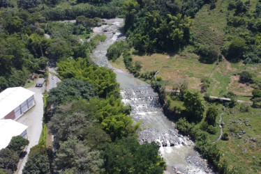 Cuarenta años después de la avalancha del Volcán Nevado del Ruiz, que arrasó barrios en Chinchiná el 13 de noviembre de 1985, los sobrevivientes siguen trabajando junto al río Chinchiná. La imagen aérea muestra el lugar donde estuvo el barrio El Río, completamente borrado del mapa por la corriente.