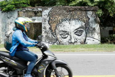 Fotografía del 5 de noviembre de 2025 que muestra a una persona transitando en motocicleta frente 