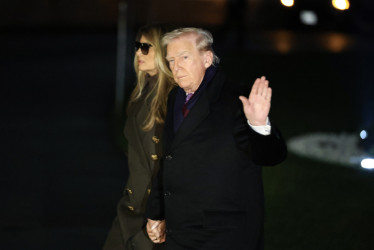 El presidente de Estados Unidos, Donald Trump, y la primera dama, Melania Trump, saludan a su regreso a la Casa Blanca este domingo, en Washington (Estados Unidos).