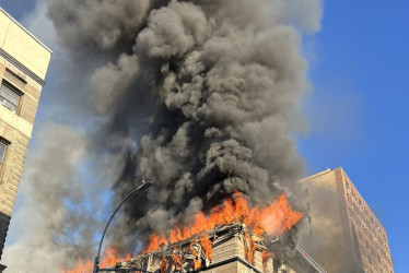 Fotografía divulgada por el Departamento de Bomberos de Nueva York (FDNY) donde aparecen bomberos controlando un incendio este martes, en Nueva York (Estados Unidos).