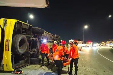 Rescatistas cargan a un sobreviviente de los restos del bus accidentado en Java (Indonesia).