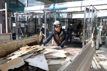 Un trabajador limpia escombros en un centro comercial en Hachinohe, prefectura de Aomori, noreste de Japón.