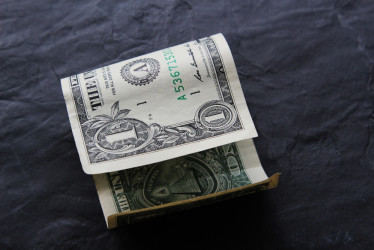 Billete de un dólar sobre una superficie negra