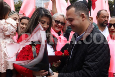 Mariana Grajales recibiendo el ramo de rosas y la tarjeta de manos de Jonier Alejandro Ramírez, alcalde de Villamaría.