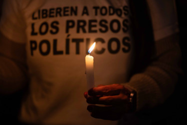 Una persona sostiene una vela en una vigilia frente al centro penitenciario Rodeo I este viernes, en Zamora estado de Miranda (Venezuela). 