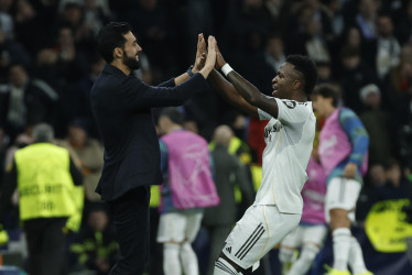 El técnico del Real Madrid, Álvaro Arbeloa y el jugador del equipo blanco, Vinicius Junior, celebran el cuarto gol del equipo madridista durante el encuentro correspondiente a la Liga de Campeones UEFA que disputan este martes el Real Madrid y el AS Mónaco, en el estadio Santiago Bernabéu en Madrid.