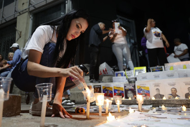 Una persona enciende una vela frente al Helicoide en Caracas (Venezuela). Los excarcelados en ese país son 626, según la presidenta encargada, Delcy Rodríguez.