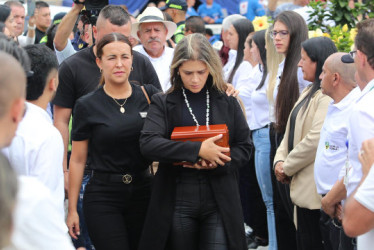 Sonia Restrepo transita por la calle de honor que hizo la comunidad portando en sus manos las cenizas de su esposo, Yeison Jiménez, artista de música popular fallecido el pasado 10 de enero en un accidente aéreo. En la imagen la acompaña Lina Jiménez, hermana del cantante.