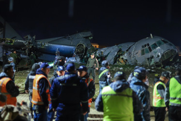 Integrantes de las Fuerzas Militares de Bolivia custodian un avión militar de carga accidentado este viernes, en El Alto (Bolivia).