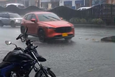 Un fuerte aguacero cayó en la tarde de este viernes en Manizales. En la foto, un carro pasa por encima de una tapa de alcantarilla que se levanta por la fuerza del agua en el sector de Los Agustinos.