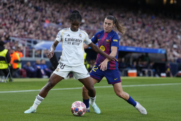 La centrocampista del Barcelona Patri (d) disputa un balón con la delantera del Real Madrid Linda Caicedo (i) este jueves durante el encuentro correspondiente a la vuelta de los cuartos de final de la Champions femenina, disputado entre el FC Barcelona y el Real Madrid en el Camp Nou de Barcelona. 
