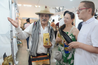 Jairo Elías Vásquez, de la vereda Guacas de Manizales, expone su producto especial Café Vasca, en Café Fest 2026. Felipe Botero y Andrea Sánchez llegaron al estand que el señor atiende con su hijo Jacobo Vásquez.