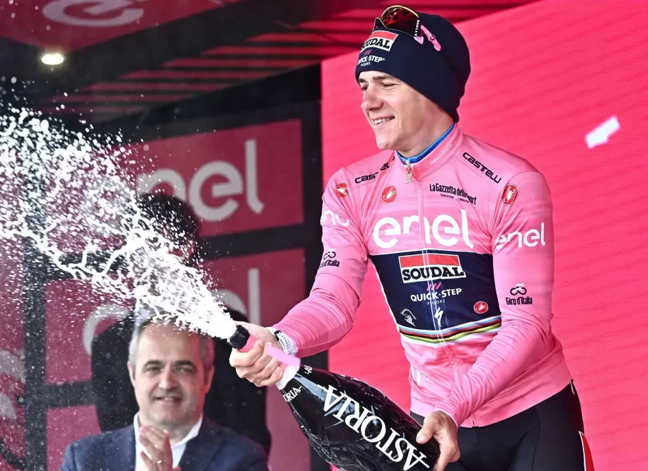 El belga Remco Evenepoel del equipo Soudal Quick-Step celebra en el podio vistiendo el maillot rosa de líder general después de ganar la novena etapa de la carrera ciclista Giro de Italia 2023, una contrarreloj individual de 35 km desde Savignano sul Rubicone hasta Cesena, Italia.