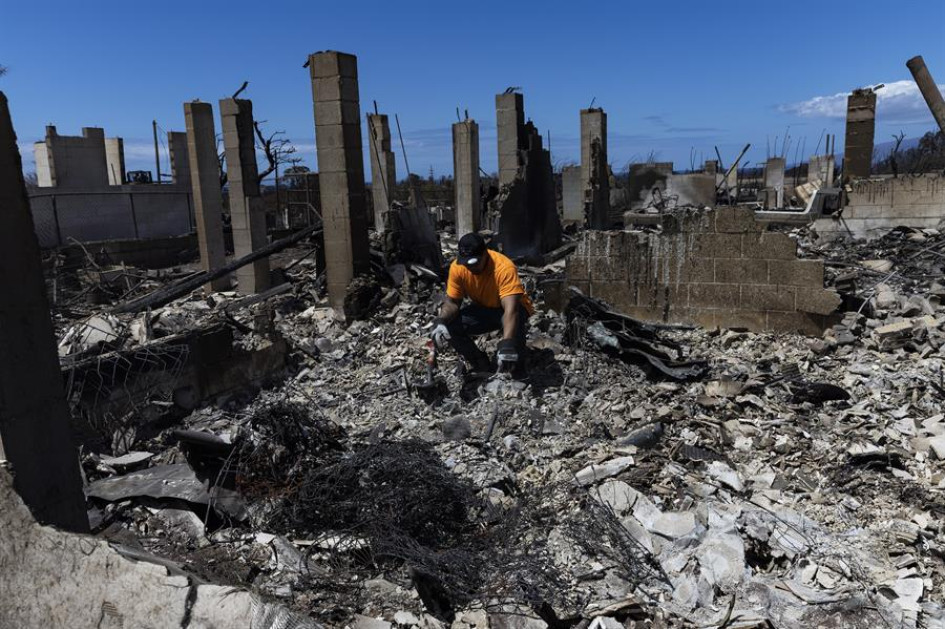 Un ciudadano hawaiano busca la urna con las cenizas de su hijo en las ruinas de lo que alguna vez fue su dormitorio destruido este jueves por un incendio forestal en la isla de Lahaina, en Hawái.