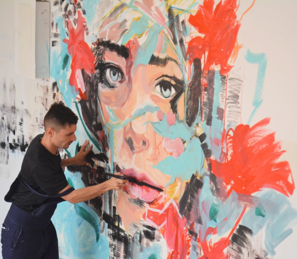 Andrés Felipe Buitrago pintando su mural en la sede del Campus Bicentenario. 