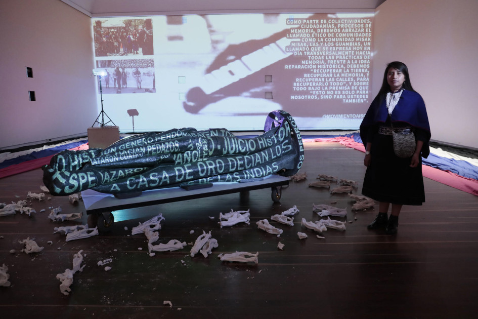 La integrante del pueblo Misak Indy Fernández posa junto a la estatua de Gonzalo Jiménez de Quesada, fundador de Bogotá, en una intervención digital.
