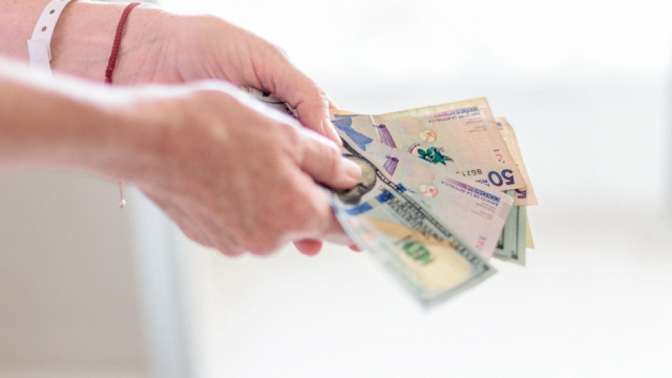 Manos con billetes colombianos