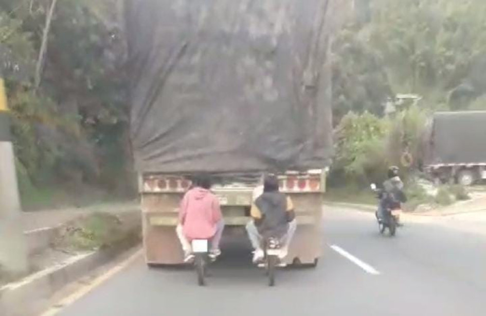 Cuatro jóvenes, montados en dos bicicletas, fueron captados en video sujetados de la parte trasera de un tractocamión en Manizales.