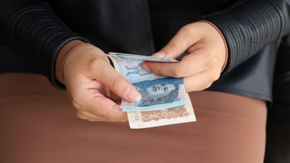 Persona con billetes de pesos colombianos.