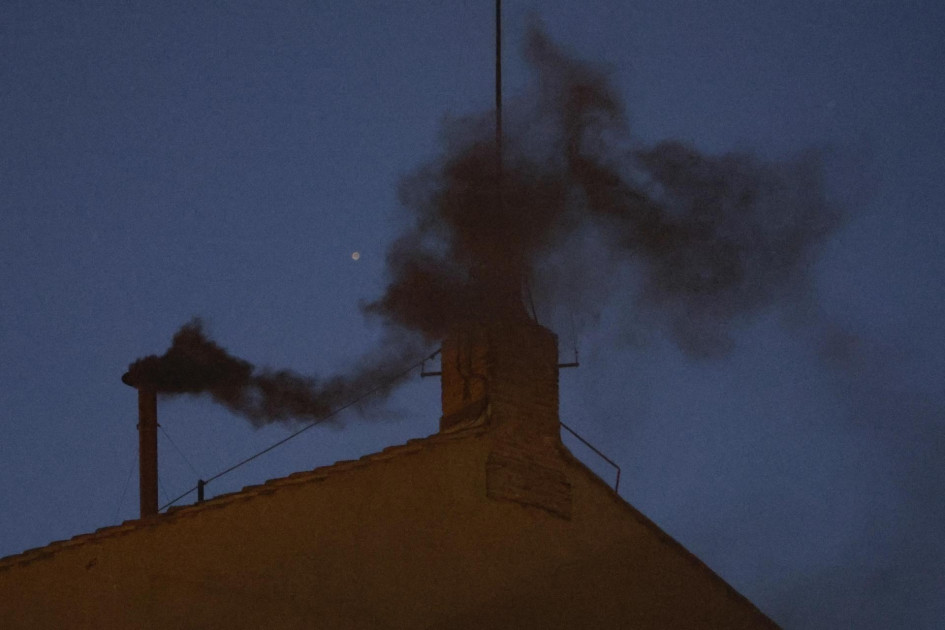 Sale humo negro de la chimenea del tejado de la Capilla Sixtina