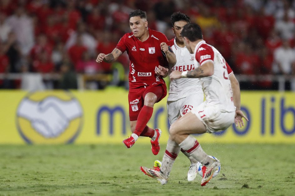 Juan Fernando Quintero (izq.) disputa un balón con César Ibáñez, en el partido que América y Huracán empataron sin goles en Cali por la Copa Sudamericana.