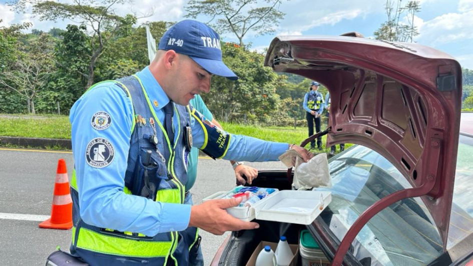 Un agente de tránsito verifica el equipo de seguridad de un vehículo durante un operativo en Manizales.