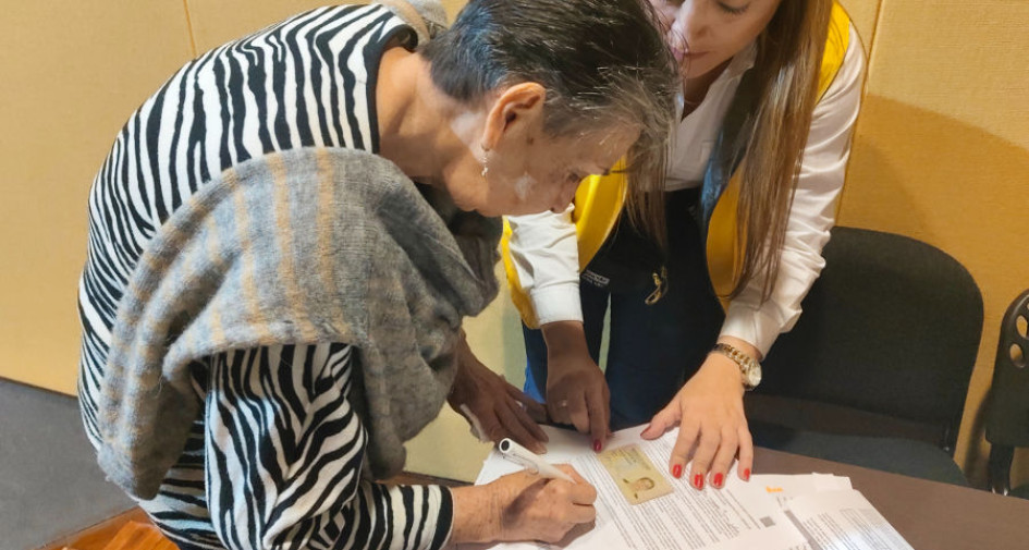 Offir Vélez firma la carta de indemnización como víctima del conflicto armado en Caldas. 