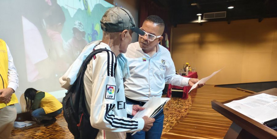 Adit Rafael Romero Polanco, director general de la Unidad de Víctimas, entrega una carta de indemnización a una víctima del conflicto armado en Manizales. 