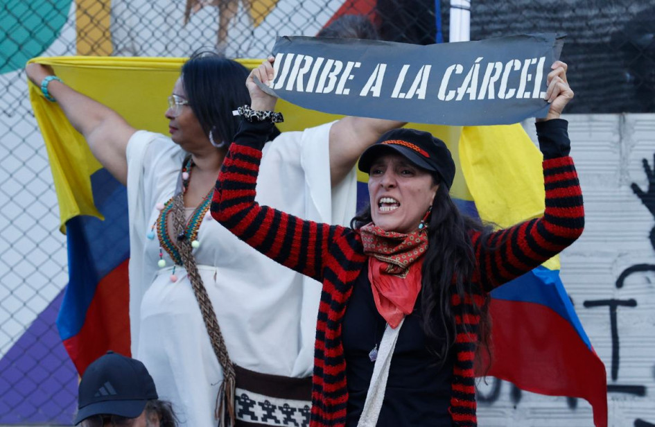 Una detractora del expresidente de Colombia, Álvaro Uribe, sostiene un cartel frente al Complejo Judicial de Paloquemao. 