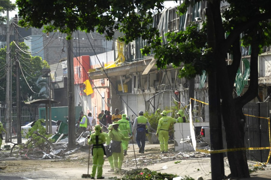 Personal de aseo recoge escombros en una calle cercana a la Escuela Militar de Aviación Marco Fidel Suárez este viernes, en Cali (Colombia).