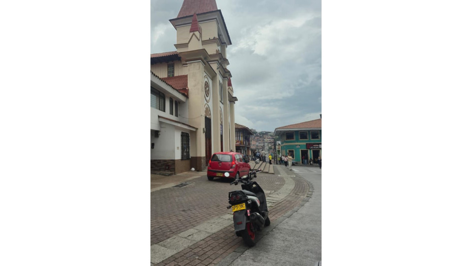 Hay vehículos que se parquean en el atrio de la iglesia de Villamaría.