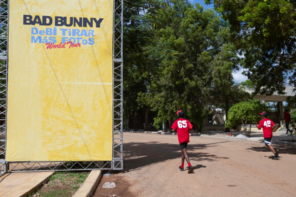  Personas pasan frente a una valla publicitaria previo al concierto del cantante puertorriqueño Bad Bunny, este jueves, en Santo Domingo (República Dominicana).