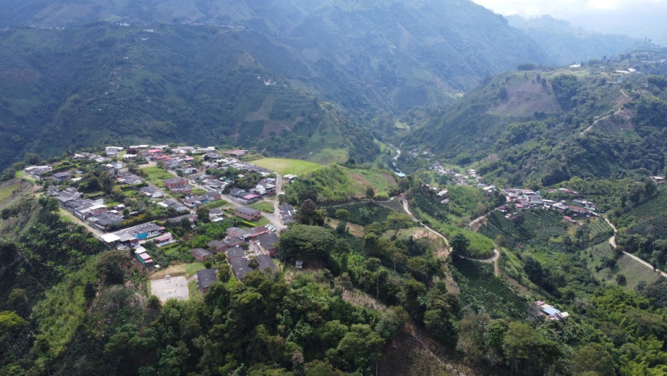 Panorámica aérea que muestra la actual vereda Nuevo Rioclaro (a la izquierda) y el antiguo caserío que afectó la avalancha (a la derecha), junto al río Chinchiná.