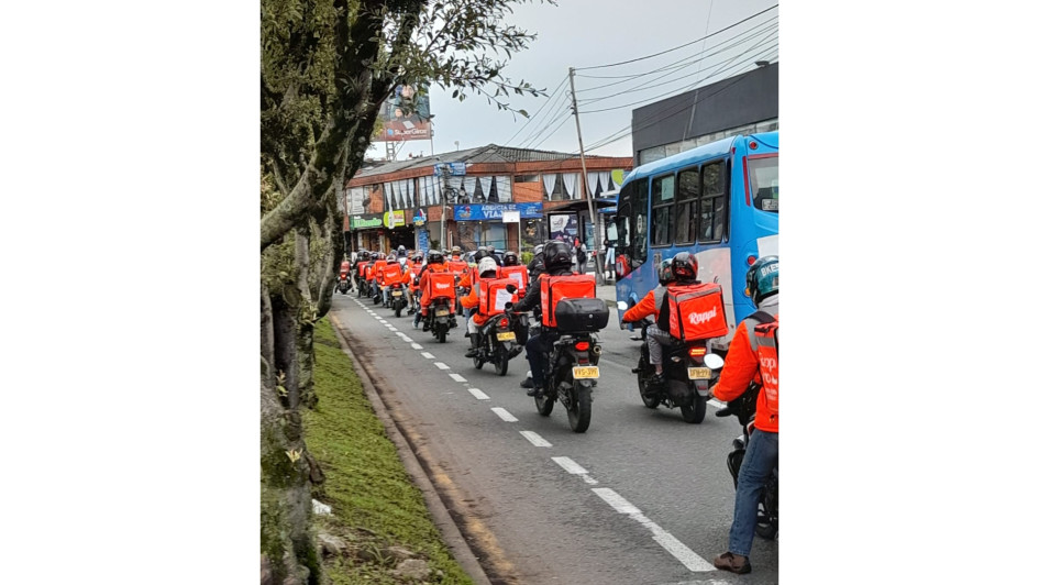 Domiciliarios de Rappi protestaron encadenados simbólicamente a sus maletas en la avenida Santander y el Centro de Manizales. Rechazan tarifas bajas y exigen diálogo con la empresa.