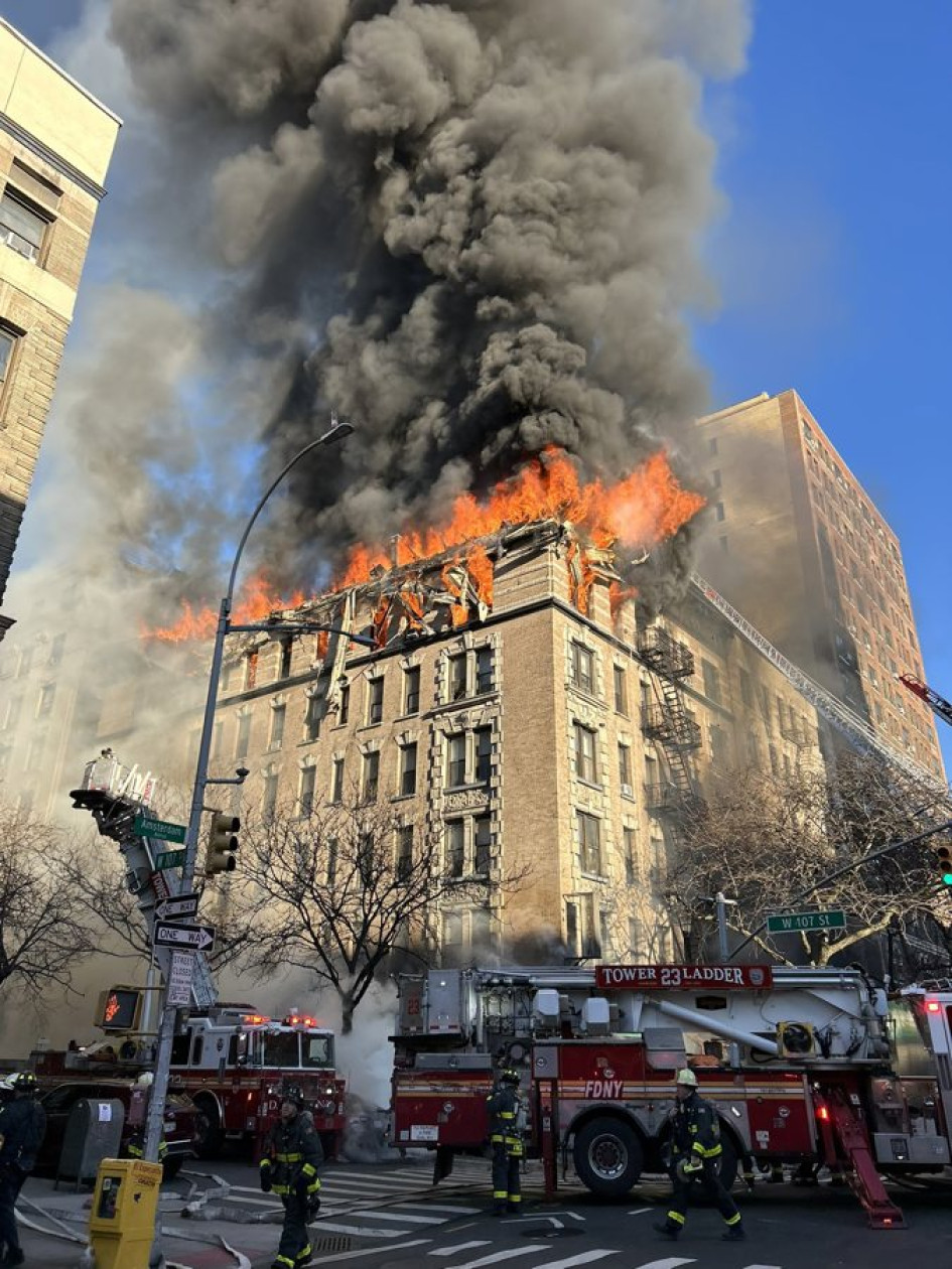 Fotografía divulgada por el Departamento de Bomberos de Nueva York (FDNY) donde aparecen bomberos controlando un incendio este martes, en Nueva York (Estados Unidos).