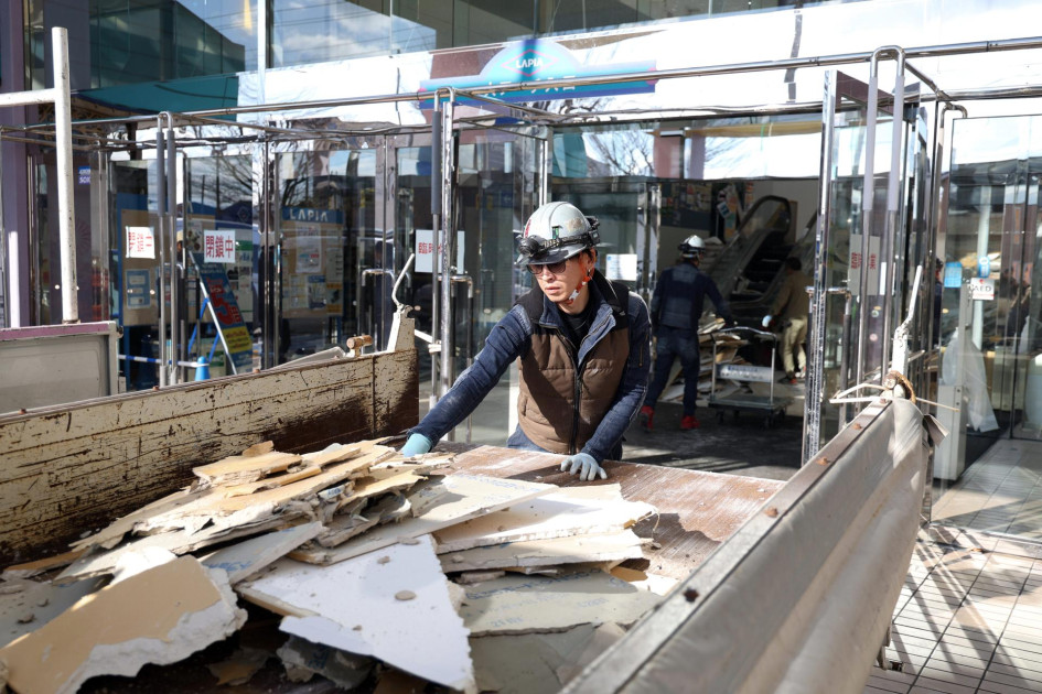Un trabajador limpia escombros en un centro comercial en Hachinohe, prefectura de Aomori, noreste de Japón.