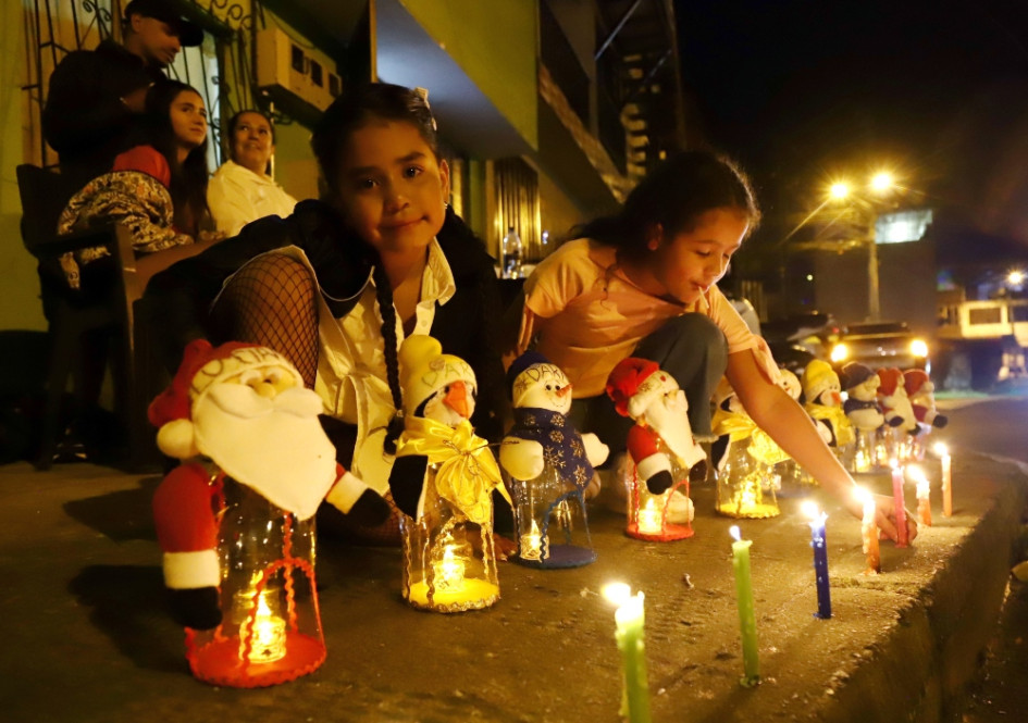 María Paz Álvarez (i) y su sobrina Antonella Arciniegas acomodan los muñecos de nieve y Papá Noel que llevan los nombres de los siete integrantes de la familia, además de la mascota. Están hechos de material recicable y las dos pequeñas disfrutan del alumbrado en el barrio Bengala de Manizales.