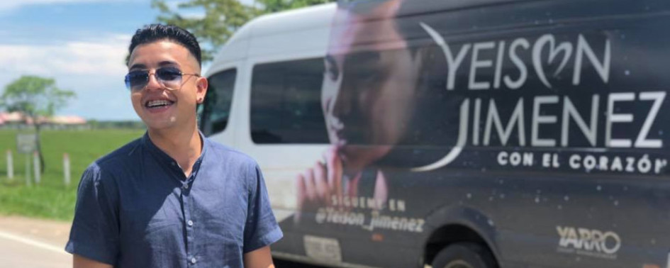 uan Manuel Rodríguez posa para la foto teniendo de fondo el bus del intérprete de música popular Yeison Jiménez. 