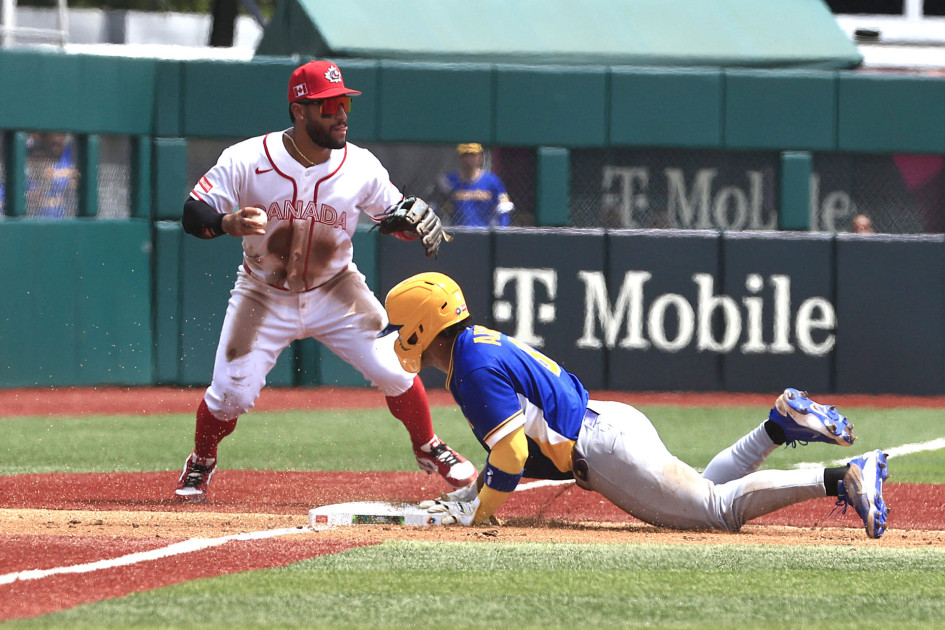 Michael Arroyo (d) de Colombia se desliza en tercera base ante Abraham Toro de Canadá este sábado, en un partido del Clásico Mundial de Béisbol entre Canadá y Colombia en el estadio Hiram Bithorn en San Juan (Puerto Rico).