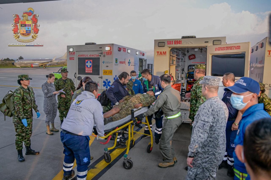 Integrantes de organismos de rescate trasladan a un herido de un accidente aéreo este lunes, en el Comando Aéreo de Transporte Militar (Catam) en Bogotá. 