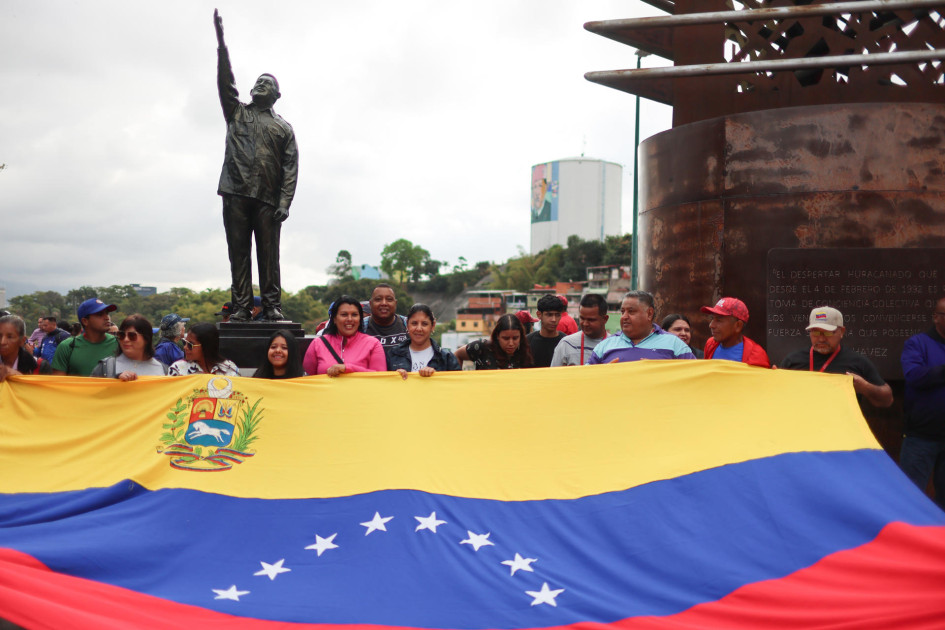 Personas junto a la estatua de Hugo Chávez en Caracas conmemoran el decimotercer aniversario de la muerte del presidente.