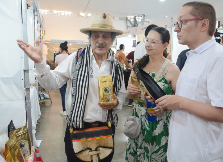 Jairo Elías Vásquez, de la vereda Guacas de Manizales, expone su producto especial Café Vasca, en Café Fest 2026. Felipe Botero y Andrea Sánchez llegaron al estand que el señor atiende con su hijo Jacobo Vásquez.