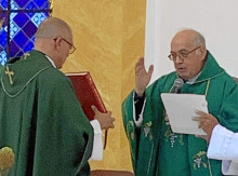 El sacerdote Edison Hernández recibe el libro de los evangelios del vicario de la Arquidiócesis.